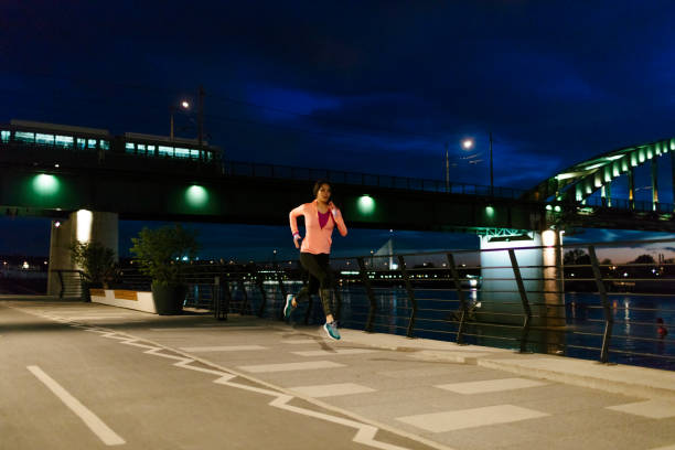 istock Young Woman Jogging At Night Near River. 526711188