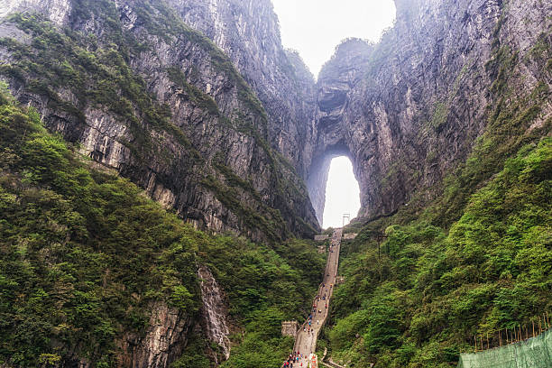 tianmen cave in tianmen national park tianmen cave or heavens door. a large water eroded hole between the two peaks. Taken in tianmen mountain national park in zhangjiajie, china zhangjiajie photos stock pictures, royalty-free photos & images