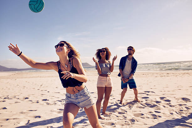 amigos jugando voleibol de playa - vóleibol de playa fotografías e imágenes de stock