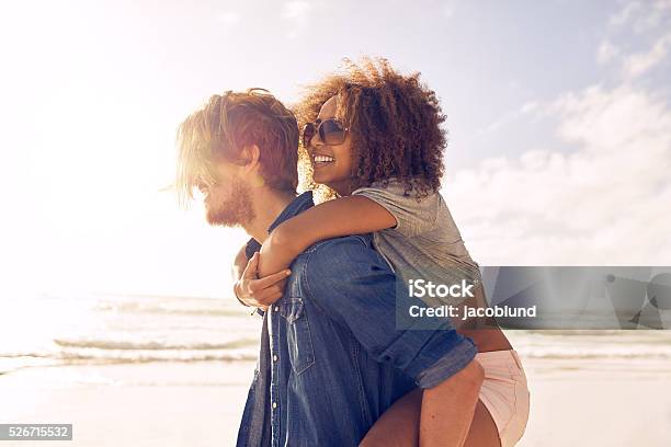 Young Couple Enjoying Their Summer Vacation On Beach Stock Photo - Download Image Now