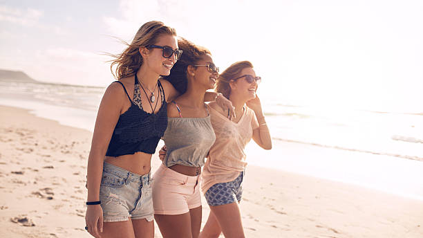 istock Happy young women strolling along coastline 526715578