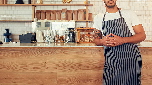istock Man standing at a coffee shop counter with an apron 526716028