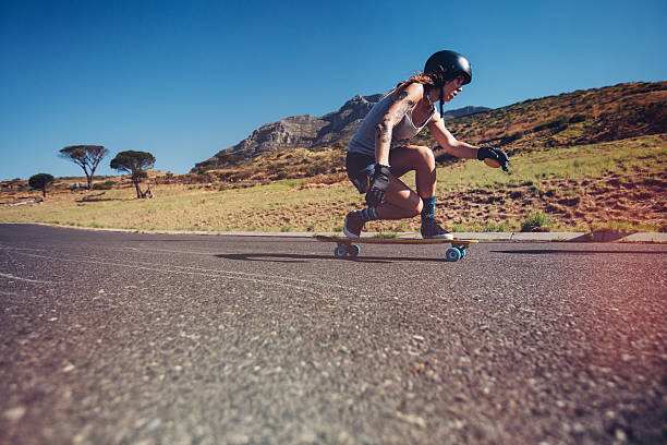 istock Young woman longboarding on a road 526716982