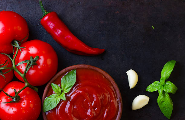 istock Tomato sauce salsa and ingredients, dark stone background. Top view 526719850