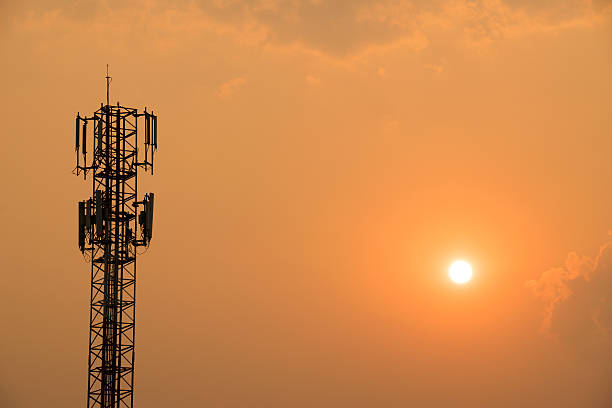 istock Cell Phone Antenna Tower on orange sky and sun 526720028