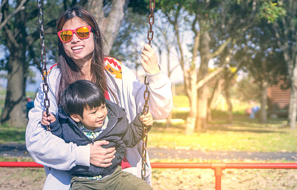 istock Asian Mother holding her child on a Swing 526723868