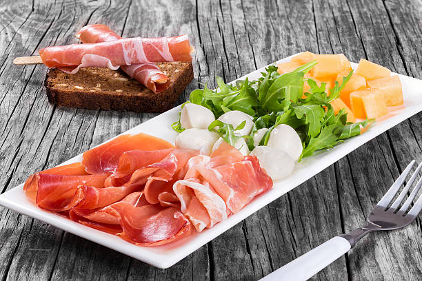istock Arugula, prosciutto, mozzarella and melon  salad , top view 526725254