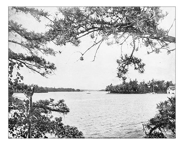 Antique photograph of view of some of "Thousand Islands" (USA-Canada) Antique photograph of one of the small island that are part of the so called "Thousand Islands", an archipelago of 1,864 islands located in the Saint Lawrence River, partially in Ontario (Canada), and partially in the United States (state of New York). In the picture part of some islands, with in particular one island with a woodland and a cottage, as it was in the late 19th century sandbanks ontario stock illustrations