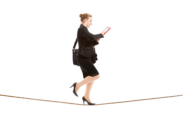 istock Businesswoman Tightrope Walker Using Digital Tablet Computer on White Background 526728399