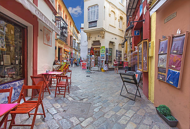 Seville - Little streets in the Santa Cruz district Seville, Spain - October 28, 2014: Little streets with the shops and restaurants in the Santa Cruz district - Calle Ximenez de Enciso street. santa cruz seville stock pictures, royalty-free photos & images