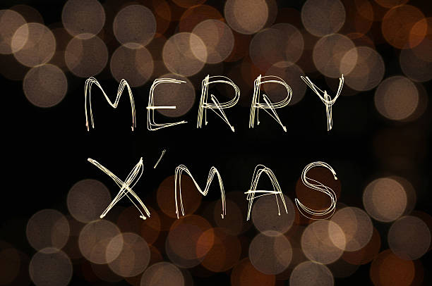 istock Merry X' Mas sparkle firework with defocused gold bokeh backgrou 526729481