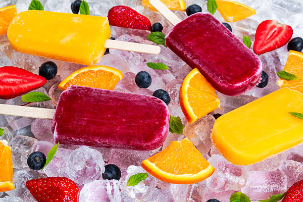 istock refreshing fruit popsicle lollies on ice background with berries, peppermint. 526730018