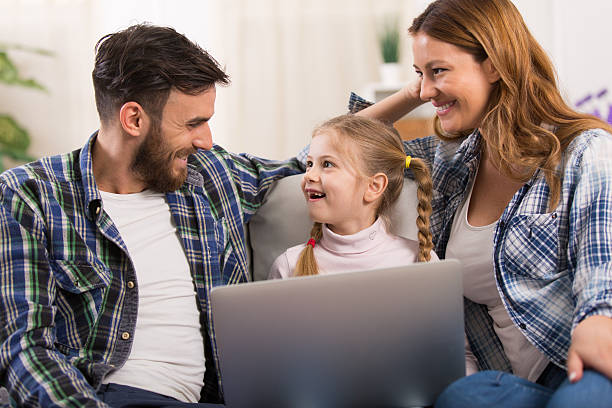 istock Cheerful family is spending free time entertaining with laptop. 526731072