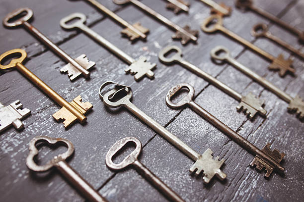 istock Some door keys aligned on old wooden surface, safety and 526732706