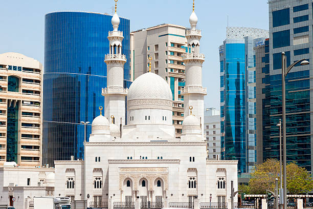 Mosque Minaret in Dubai city, apartments and futuristic office buildings are seen in the background, United Arab Emirates,