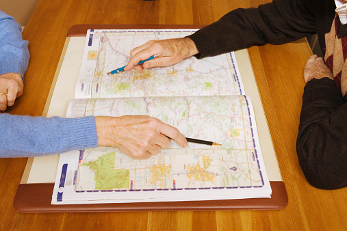 Senior couple pointing at destinations on map