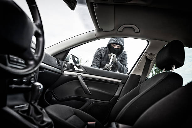 Thief in a mask hijacks the car stock photo