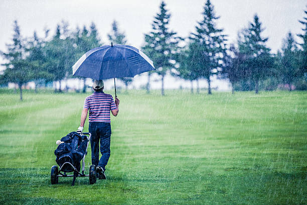 Golfer on a Rainy Day Leaving the Golf Course stock photo