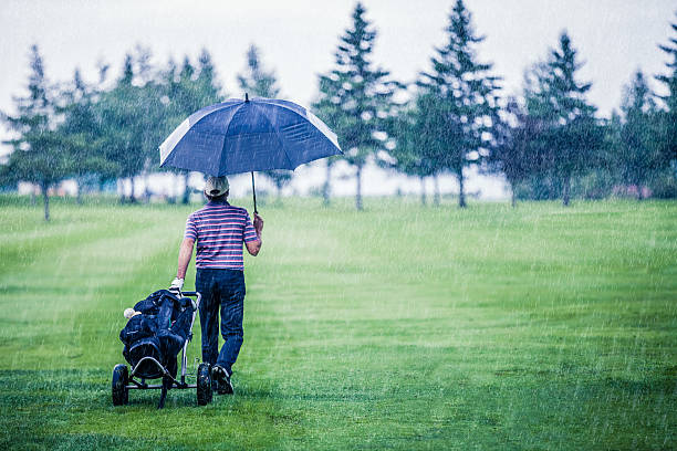 golfista w deszczowy dzień, pozostawiając pole golfowe - old senior adult one person rudeness zdjęcia i obrazy z banku zdjęć