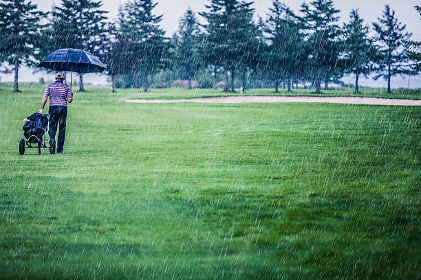 golfe em um dia chuvoso de deixar o campo de golfe - rain drenched men wet imagens e fotografias de stock