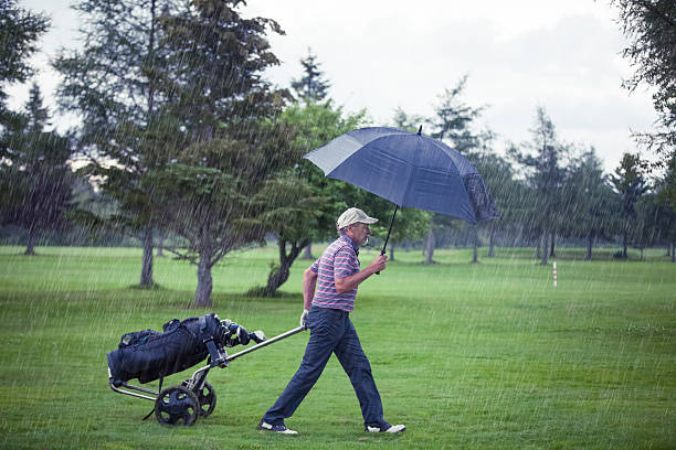 golfe em um dia chuvoso de deixar o campo de golfe - rain drenched men wet imagens e fotografias de stock