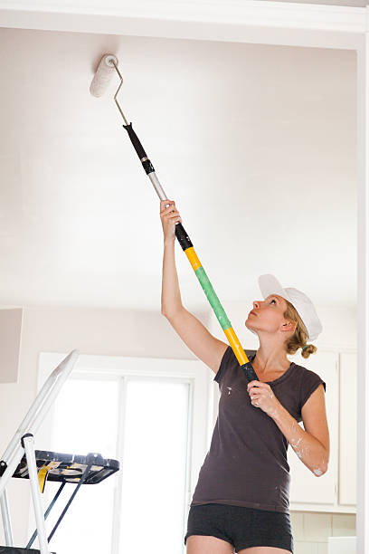 Closeup of Woman Painting the Ceiling stock photo