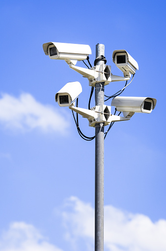 security cameras in front of blue sky - with space for text