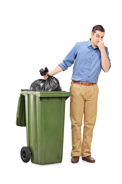 istock Man throwing out a stinky bag of trash 526750017