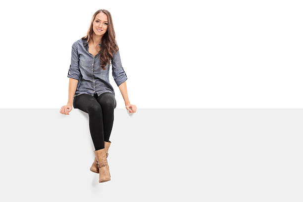 istock Young girl sitting on a blank billboard 526760107