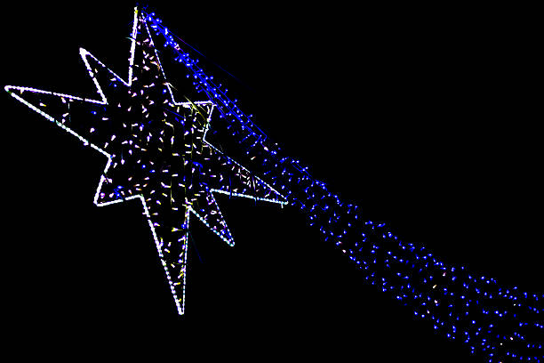 Illuminated neon Christmas star against a black sky. Copy space on the black background.