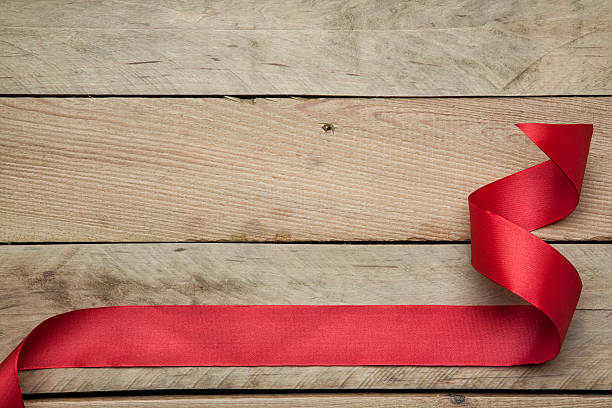 istock Red ribbon on wooden background 526760769