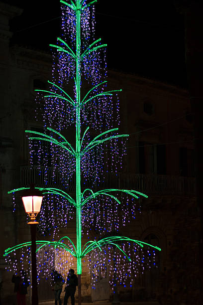 istock Illuminated Neon 3-D Electric Christmas Tree Against Black Sky 526764289