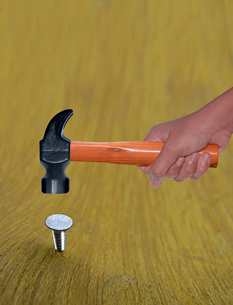 Hammer in Human Hand hitting a nail Hammer in Human Hand hitting a nail hit the nail on the head stock pictures, royalty-free photos & images