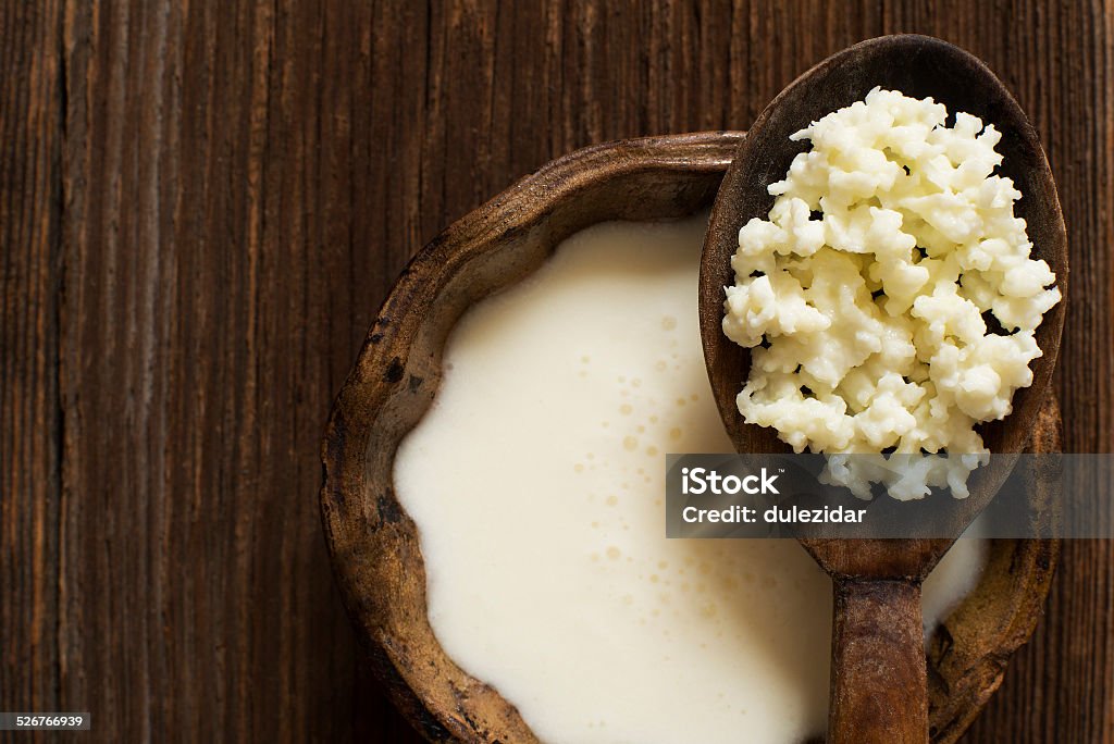 Milk kefir Milk kefir grains on a wooden spoon overhead shoot Kefir Stock Photo