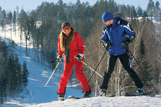 Snowdrift. A beautiful young woman on ski along with a handsome instructor against a snowfield. ski instructor stock pictures, royalty-free photos & images