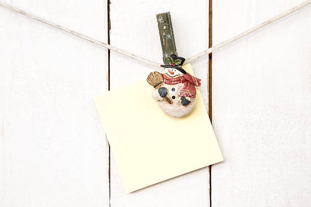 istock Christmas snowman clothespins holding blank note paper 526786733