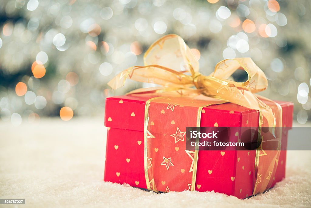 Red Christmas present on the snow Red Christmas present on the snow in front of the Christmas tree. Box - Container Stock Photo