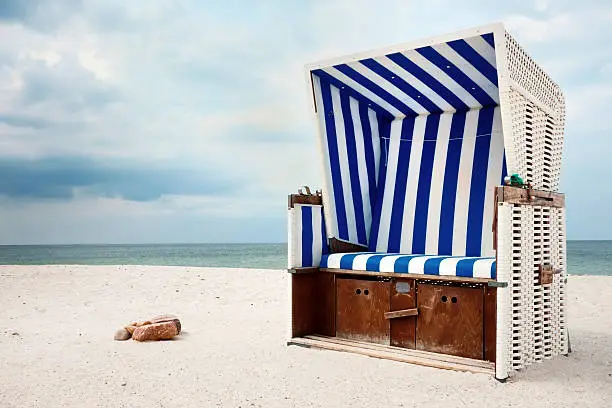 Hooded Beach Chair in the North Sea on a lonely beach. Landmark in Island Sylt, Germany