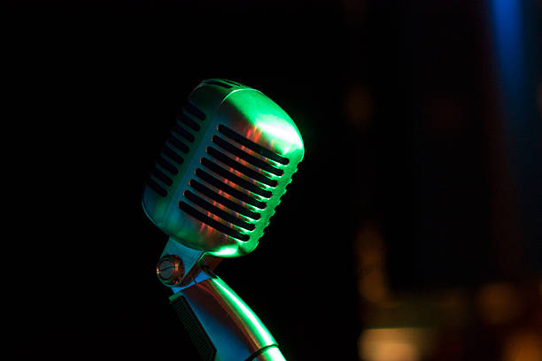 istock Vintage Microphone on stage in green light 526788753