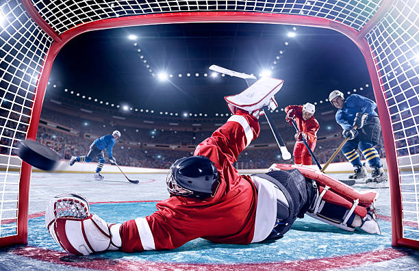 joueur de hockey sur glace de marquer - ice hockey hockey puck playing shooting at goal photos et images de collection