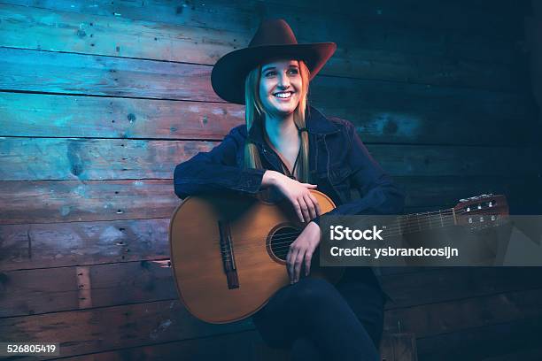 Cowgirl Country Singer With Acoustic Guitar Wearing Blue Jeans Stock Photo - Download Image Now