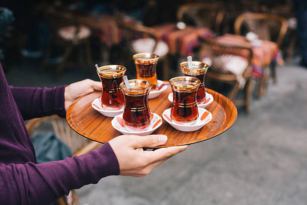 Turkish Tea Waiter serving turkish style tea in Istanbul, turkey. black tea stock pictures, royalty-free photos & images