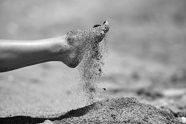 disfrute de unas vacaciones día jugando con la arena de la playa - barefoot behavior toned image close up fotografías e imágenes de stock
