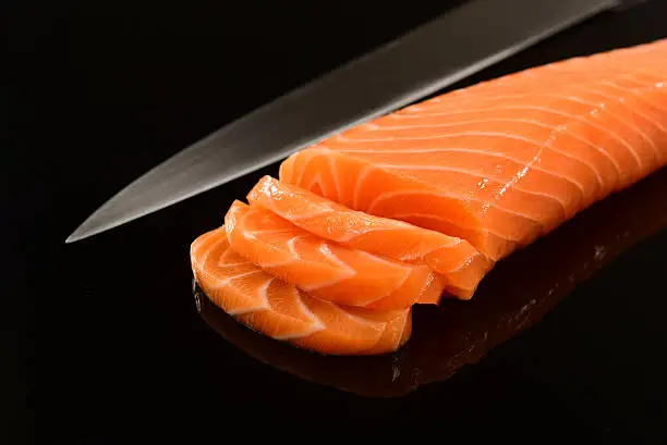 Fresh salmon fillet on black background