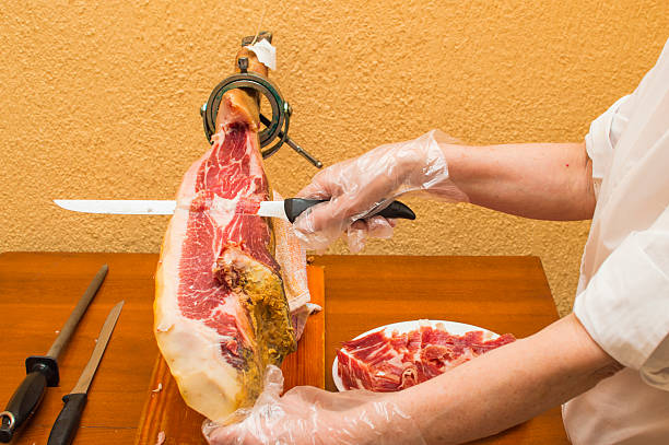 person cutting ham