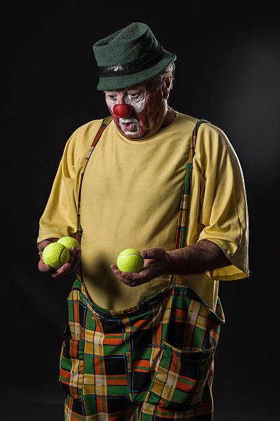 istock old-aged clown  with tennis balls 526823410
