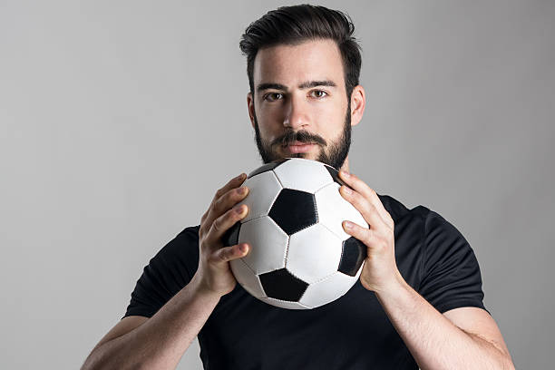 istock Friendly confident soccer player holding ball looking at camera 526823500