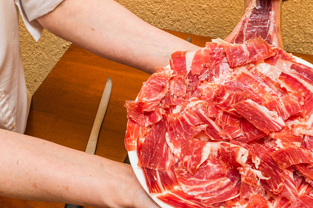 person serving a dish with ham