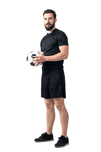 istock Confident proud football player holding ball looking at camera 526824574