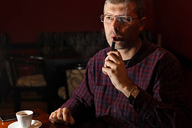 homem de fumar um cigarro eletrónico - clock face flash imagens e fotografias de stock